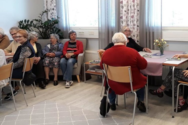 Seurakuntalaisia istuskelemassa Kahvila Ilonpisarassa.